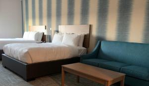 里贾纳Meridian Inn & Suites Regina Airport的酒店客房,配有床和沙发