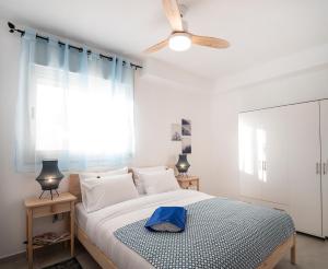 阿卡Argaman Beach Apartment的一间卧室配有一张床和吊扇