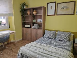 略夫雷加特河畔奥斯皮塔莱特Dos habitaciones dobles en apartamento confortable的一间卧室配有一张床、一张书桌和一个架子