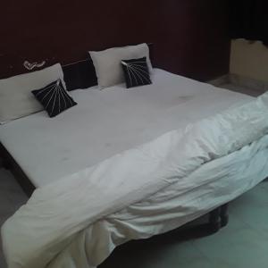 瓜廖尔shri bake bihari guest house的一张带四个枕头的大白色床
