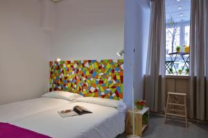 毕尔巴鄂毕尔巴鄂霹雳旅舍的一间卧室配有一张带色彩缤纷床头板的床