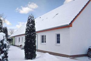 HaidhofApartment Gingst 1的白色房子,有雪盖屋顶