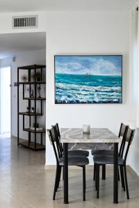 提比里亚Europa Residence的一间设有桌子和墙上绘画的用餐室