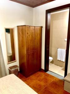 Santo AmaroNinho das Cagarras的一间带木制橱柜的卧室和一间浴室