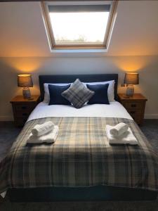 朗日The Grooms Cottage的一间卧室配有一张床,上面有两条毛巾