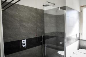 比萨阿菲塔卡马雷德尔佛酒店的浴室里设有玻璃门淋浴
