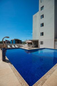 伊瓜苏巴维拉伊瓜苏酒店的一座大型蓝色游泳池,位于大楼旁边