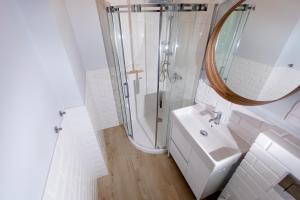 尼彻兹Apartamenty Pomona的带淋浴和盥洗盆的白色浴室