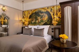巴黎Hôtel Vinci Due & Spa的卧室配有一张床,墙上挂有绘画作品