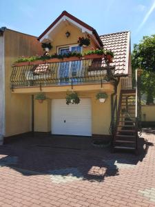 米兹多洛杰Amberek Dom Gościnny的房屋设有2扇车库门和阳台