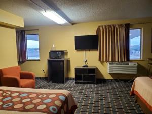 Henderson丹佛东北速8酒店的配有一张床和一台平面电视的酒店客房