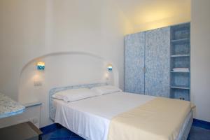 康培斯Le poste di Simplicio的卧室配有白色的床,铺有蓝色地板。