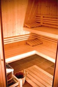 坎佩尔Manoir des Indes, The Originals Relais (Relais du Silence)的空空的桑拿浴室设有木墙和木地板