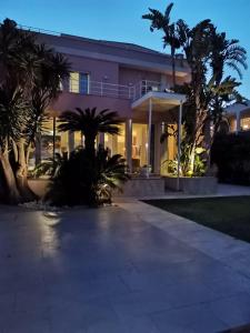 蒙德罗Villa Olimpia的前面有棕榈树的房子