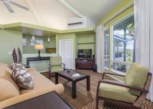 科纳霍鲁亚度假酒店的客厅配有沙发、椅子和电视