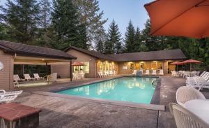 韦尔奇Whispering Woods Resort, a VRI resort的一个带椅子的游泳池以及一座房子