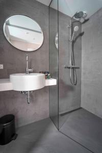 哥本哈根Motel One Copenhagen的带淋浴、盥洗盆和镜子的浴室