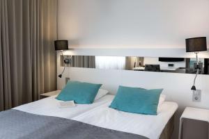图尔库斯堪迪克朱莉娅酒店的一间卧室配有白色的床和2个蓝色枕头