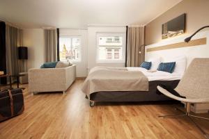 海宁格松斯堪迪克海于格松酒店的一间卧室配有一张大床和一把椅子