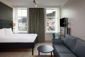 卑尔根Scandic Torget Bergen的酒店客房,配有床和沙发