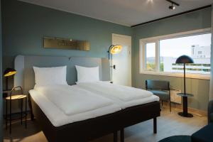 奥斯陆斯福尔斯堪迪克酒店的卧室设有一张白色大床和一扇窗户。