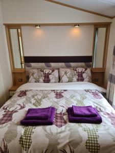 奥赫特拉德Deer lodge的床上铺有紫色枕头的床