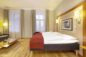 奥斯陆霍尔伯格斯堪迪克酒店的酒店客房设有一张大床和一张沙发。