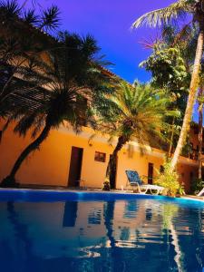 坎布里Pousada Azul Banana - Camburi的棕榈树和游泳池度假村