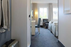 格里姆斯塔Clarion Collection Hotel Grimstad的酒店客房设有一间带一张床和一张书桌的卧室