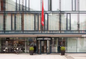 奥斯陆斯堪迪克边境酒店的一面挂旗的玻璃建筑前的商店