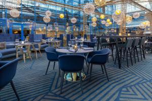 万塔赫尔辛基机场斯堪迪克酒店的用餐室配有桌椅和吊灯。