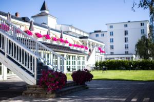 利勒哈默尔利勒哈默尔斯堪酒店的白色的建筑,楼梯上有粉红色的花朵