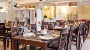 莱克内斯斯堪迪克莱克内斯罗弗敦酒店的用餐室配有木桌和椅子