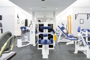 万塔Scandic Helsinki Aviapolis的健身房设有蓝色椅子和跑步机