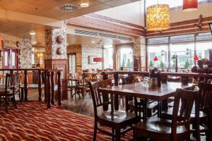 米凯利米凯利斯堪迪克酒店的餐厅设有木桌、椅子和窗户。