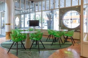 图尔库Scandic Atrium的配有绿色桌椅和电视的客房