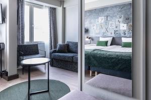 赫尔辛基斯甘迪克卡里奥酒店的一间卧室配有一张床、一把椅子和镜子