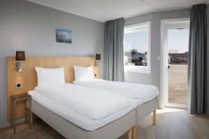 斯沃尔韦尔Scandic Vestfjord Lofoten的卧室设有一张白色大床和一扇窗户。