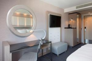 斯塔万格Scandic Royal Stavanger的一间带镜子、一张桌子和一张床的卧室