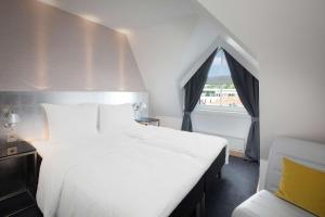 斯塔万格Scandic Royal Stavanger的卧室设有一张白色大床和一扇窗户。