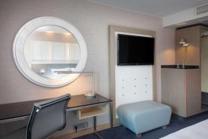 斯塔万格Scandic Royal Stavanger的一间卧室配有书桌、镜子和椅子