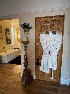 波斯考尔Olivia House的一间带有门和浴袍的浴室