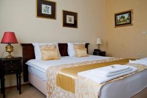 松博尔安德里奇卡尔尼酒店的一间卧室配有两张床和一张带台灯的桌子