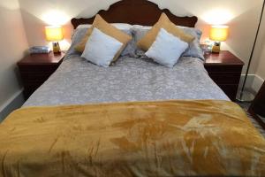 AbertilleryTranquil Welsh Mountain Gem, Abertillery, Wales的一间卧室配有一张带枕头的床和两盏灯。
