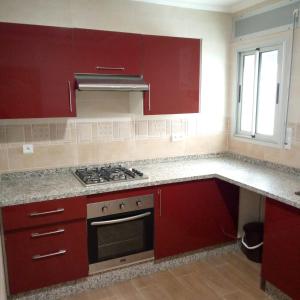 米迪克residence akram m'diq的一间带红色橱柜和炉灶的厨房