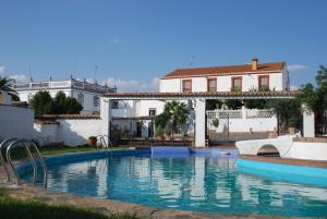 Montemolín卡萨乡村埃尔阿吉拉酒店的房屋前带滑梯的游泳池