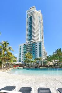 黄金海岸Crown Towers Resort Apartments的海滩上的带椅子的度假村和大楼