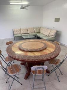 Al ‘AqarAljabal Al Akhdar Olive Tree Guest house的一张带椅子和沙发的大型木桌