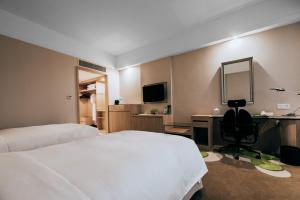 常州常州武进假日酒店的酒店客房带一张床、一张书桌和一面镜子