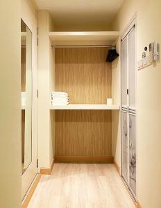 马六甲Amadel Residence 爱媄德民宿 11的步入式衣柜,铺有木地板,配有架子